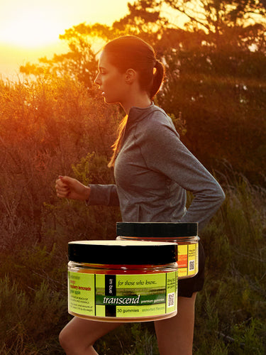 our CBD gummies placed over a young woman jogging in the mountains at sunset 