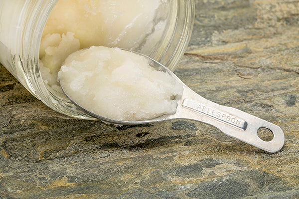 Coconut Oil in a spoon with Jar